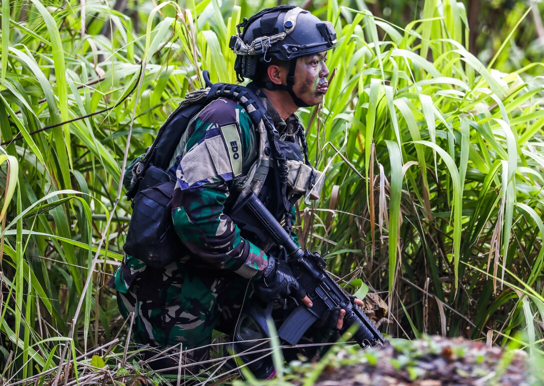 A Soldier from the Indonesian National Army simulates a fire attack and scans a sector of fire during the Joint Pacific Multi-National Readiness Center rotation 22-01 exercise on Kahuku Training Area, Hawaii on Oct. 25, 2021. JPMRC Rotation 22-01 provides the 25th Infantry Division the opportunity to integrate and train alongside our partners and allies throughout the Indo-Pacific Region. (U.S. Army photo by Sgt. Carlie Lopez/28th Public Affairs Detachment)