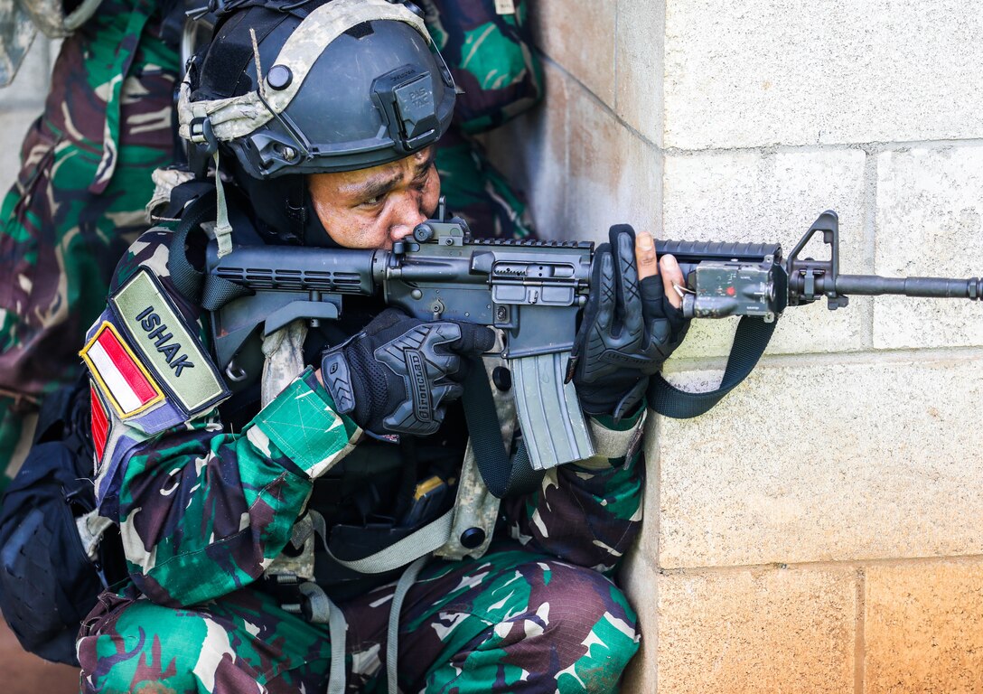 A Soldier from the Indonesian National Army simulates a fire attack and scans a sector of fire during the Joint Pacific Multi-National Readiness Center rotation 22-01 exercise on Kahuku Training Area, Hawaii on Oct. 25, 2021. JPMRC Rotation 22-01 provides the 25th Infantry Division the opportunity to integrate and train alongside our partners and allies throughout the Indo-Pacific Region. (U.S. Army photo by Sgt. Carlie Lopez/28th Public Affairs Detachment)