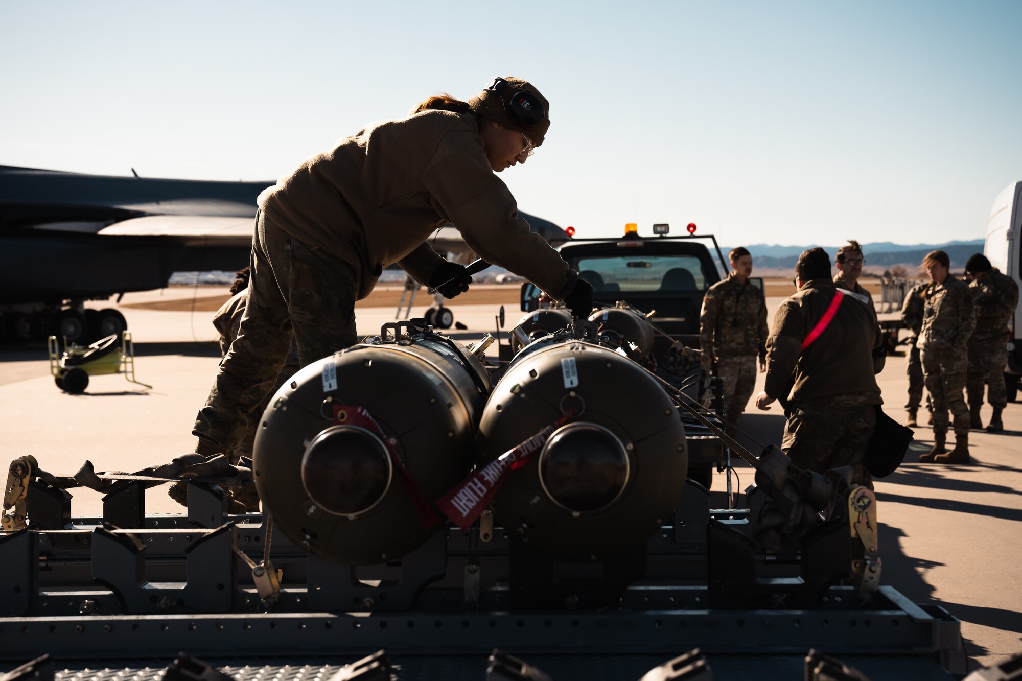 Airmen 1st Class Isabel Tapia, 28th Aircraft Maintenance Squadron weapons load crew member, inspects CBU-103 munitions before loading them onto a B-1B Lancer in preparation for a Weapon System Evaluation Program at Ellsworth Air Force Base, S.D., Nov. 7, 2022.