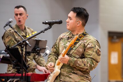 U.S. Air Force Airman 1st Class Christopher Arellano, Flight One guitarist from Band of Flight, Wright-Patterson Air Force Base, Ohio, center, rocks out with U.S. Air Force Tech. Sgt. Shawn Hanlon, keyboard player