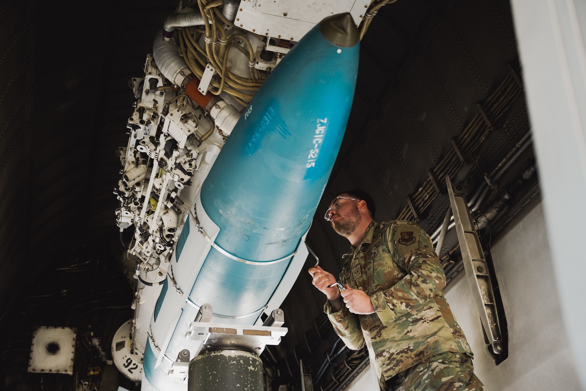 Senior Airmen Nolan Denney, 28th Aircraft Maintenance Squadron weapons load crew member, fastens a GBU-38 training munition onto a B-1B Lancer in preparation for a Weapon System Evaluation Program at Ellsworth Air Force Base, S.D., Nov. 7, 2022.