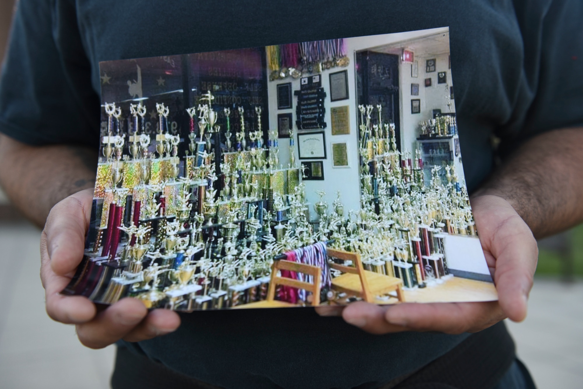 Staff Sergeant David Correa holds a photo of his collection of over 500 trophies.