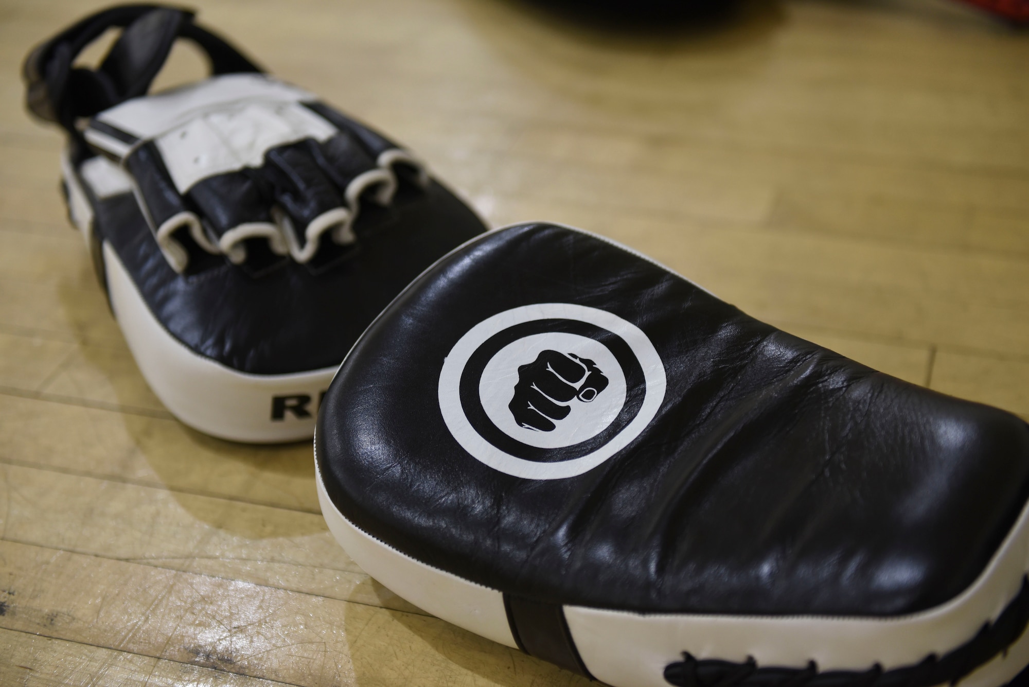 Two black and white punch mitts lay on the floor at the McGuire Fitness Center.