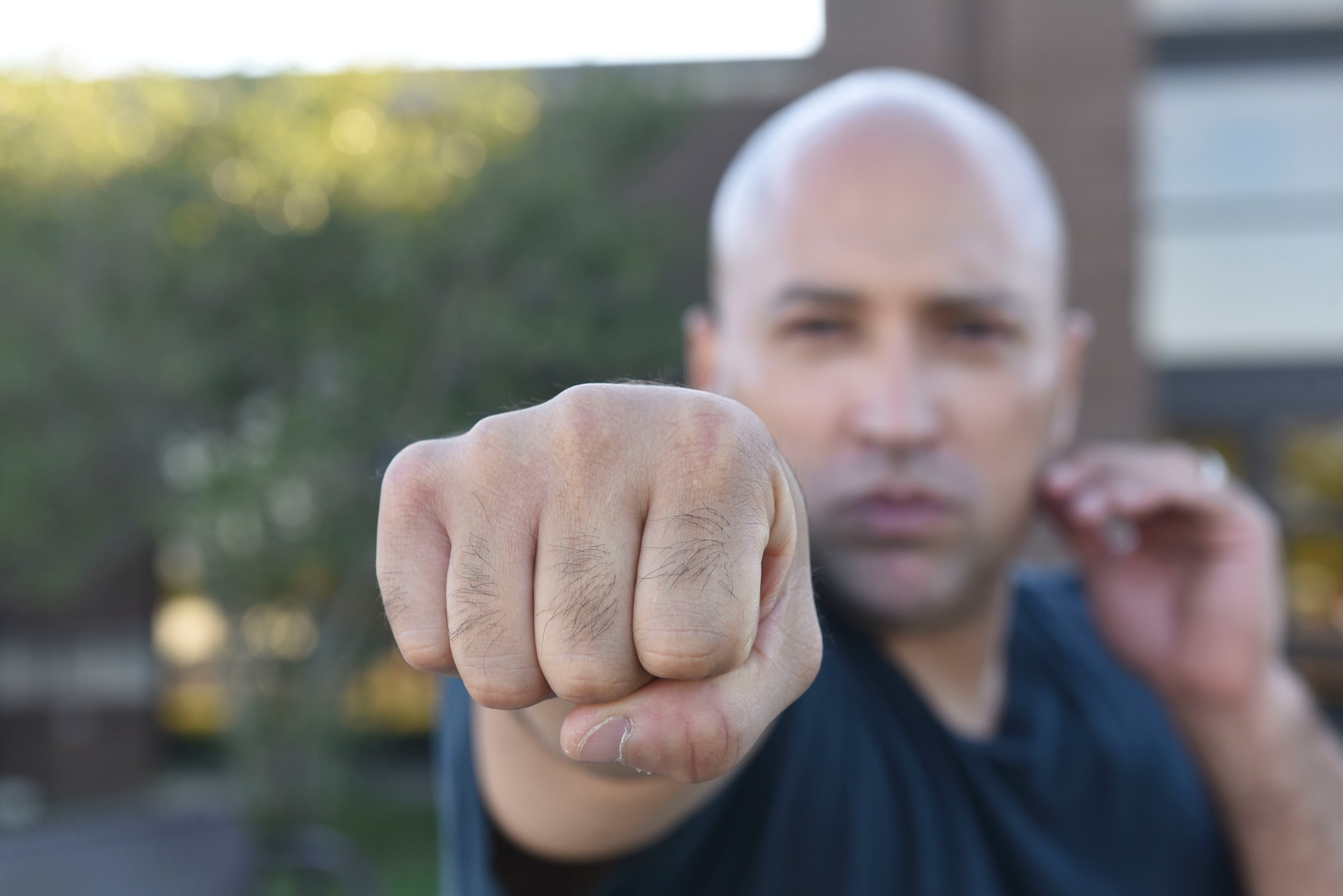 Staff Sergeant David Correa punches towards the camera while wearing a black t-shirt.
