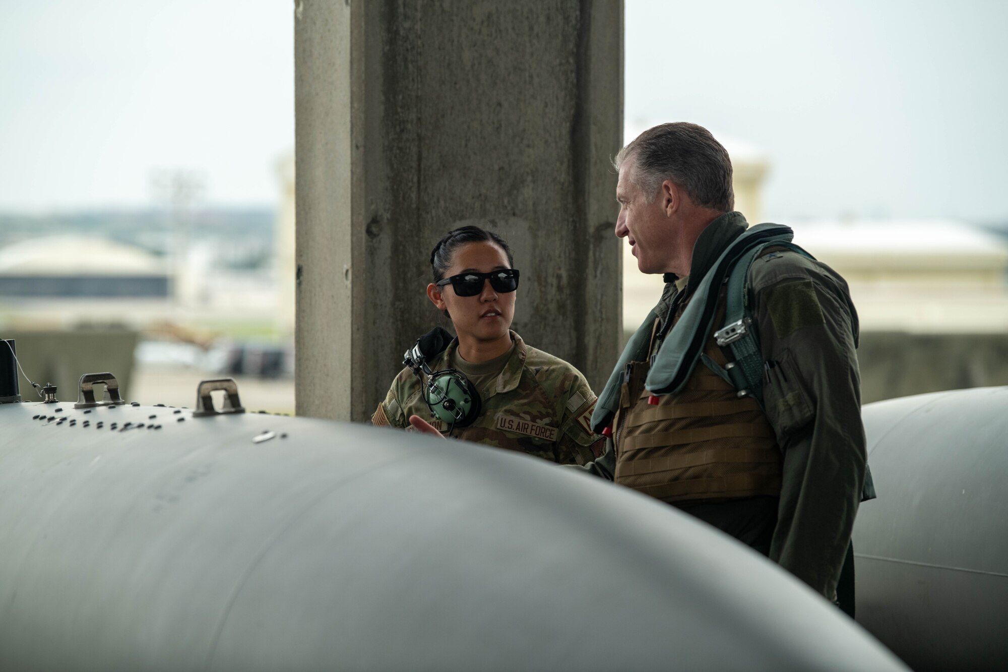 Pilot talks to a crew chief in front of a jet.