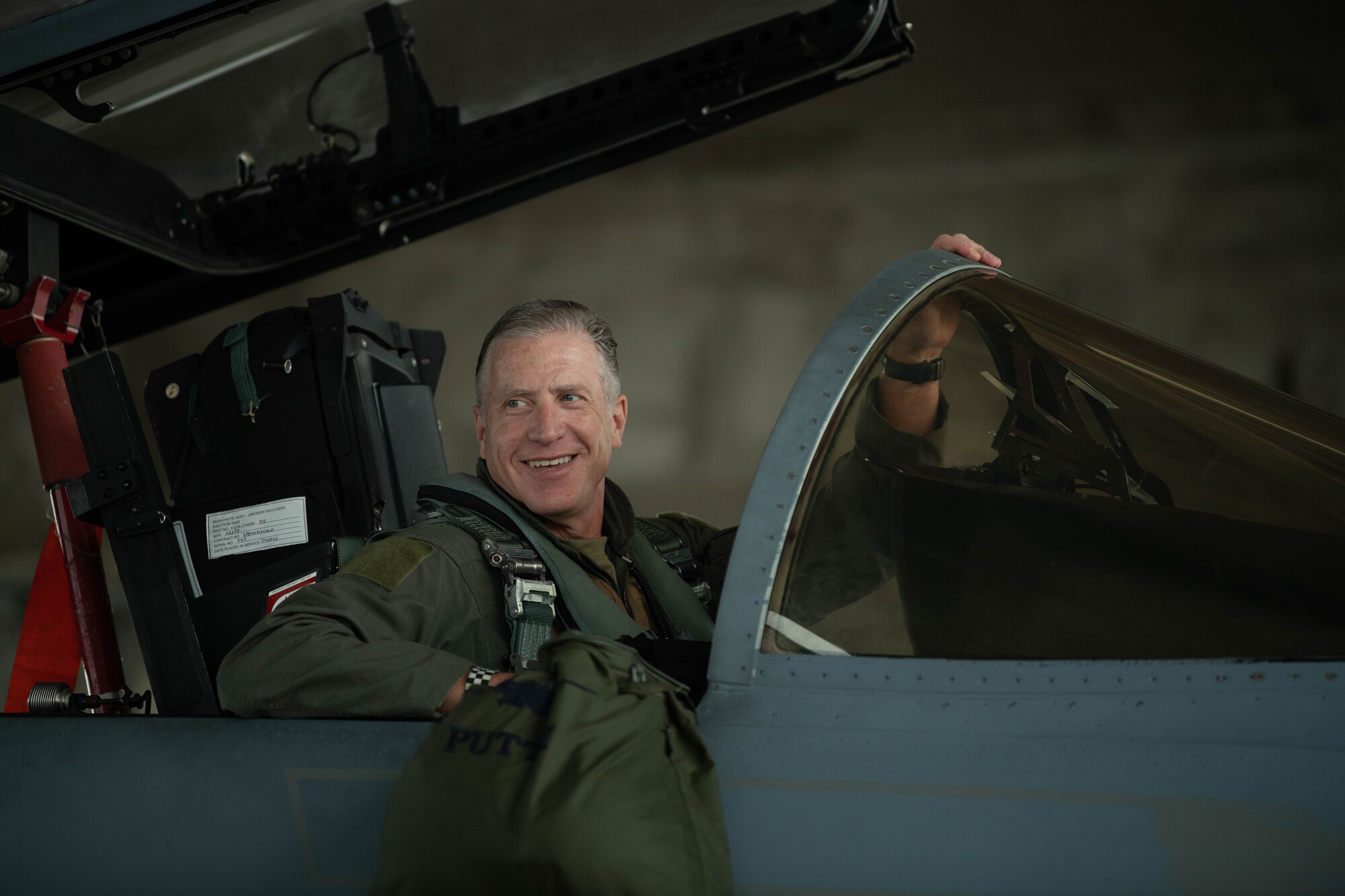 Pilot smiles inside a cockpit of an F-15.