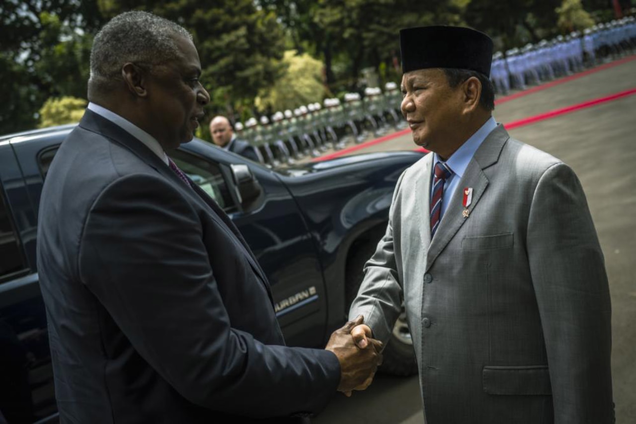 Two men shake hands.