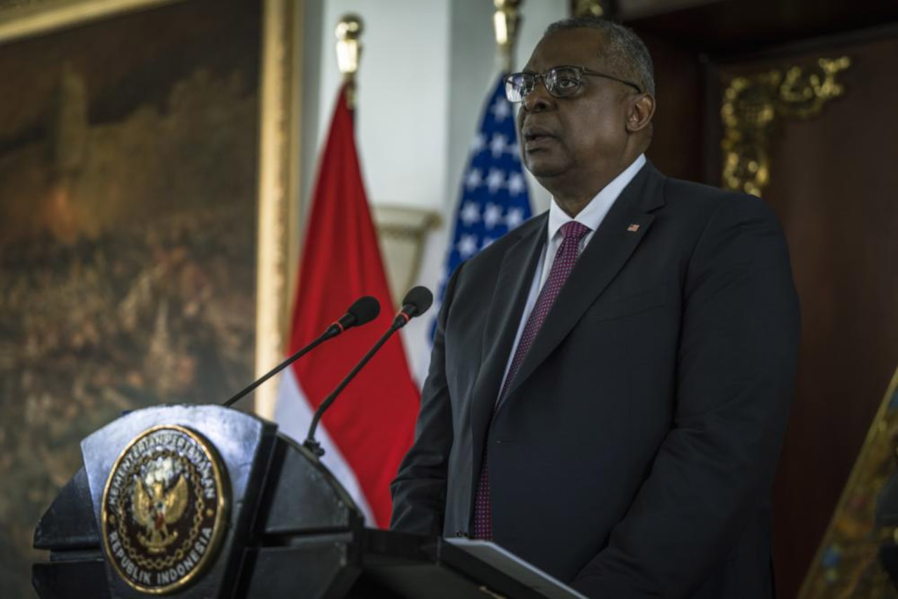 A man in a business suit stands at a podium.