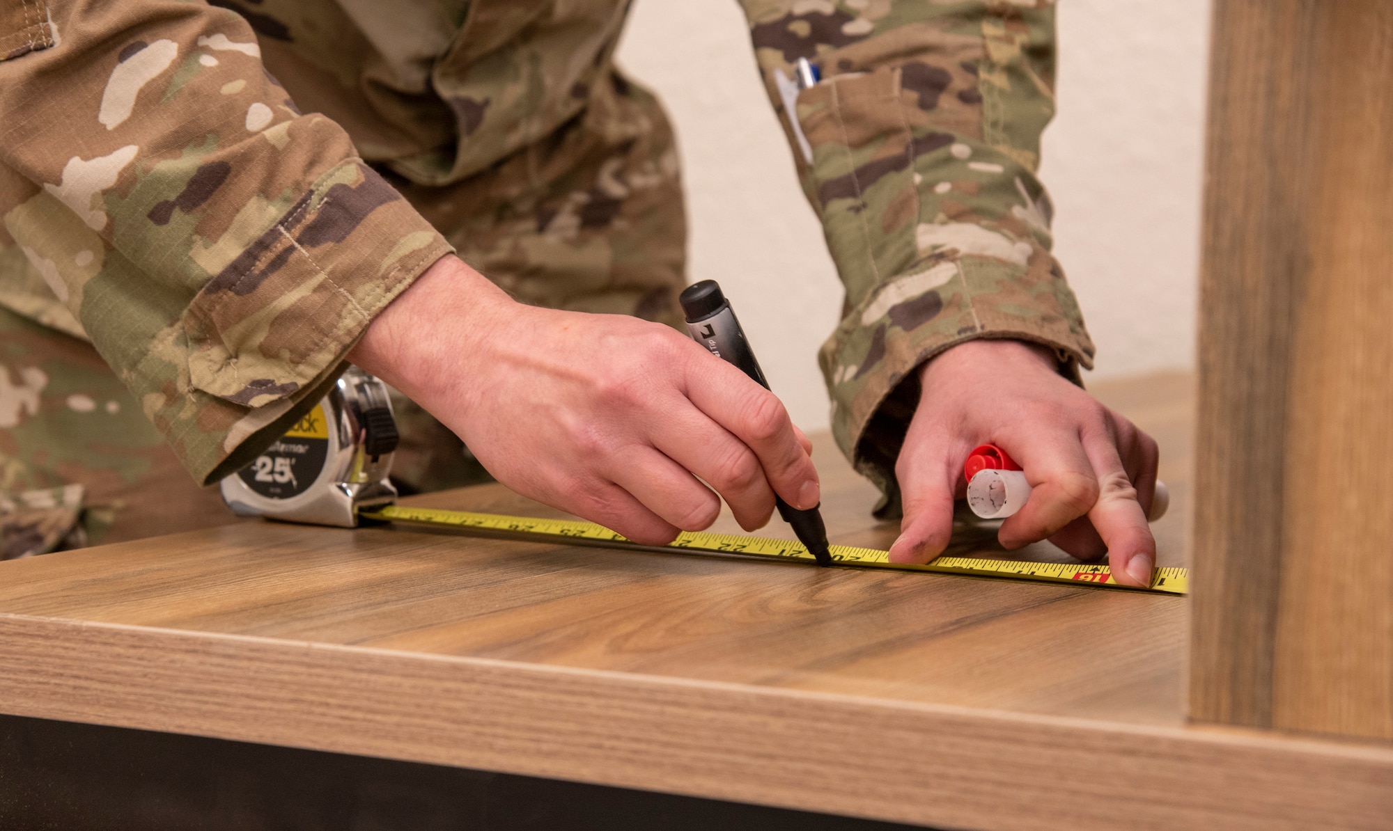 U.S. Air Force Tech. Sgt. Andrew Hart, 332d Expeditionary Communications Squadron, measures a desk to create tempest diagrams at an undisclosed location, Southwest Asia, Nov. 3, 2022. These diagrams determine where network devices will be placed in order to prevent secure and non-secure devices from connecting. (U.S. Air Force photo by: Tech. Sgt. Jim Bentley)