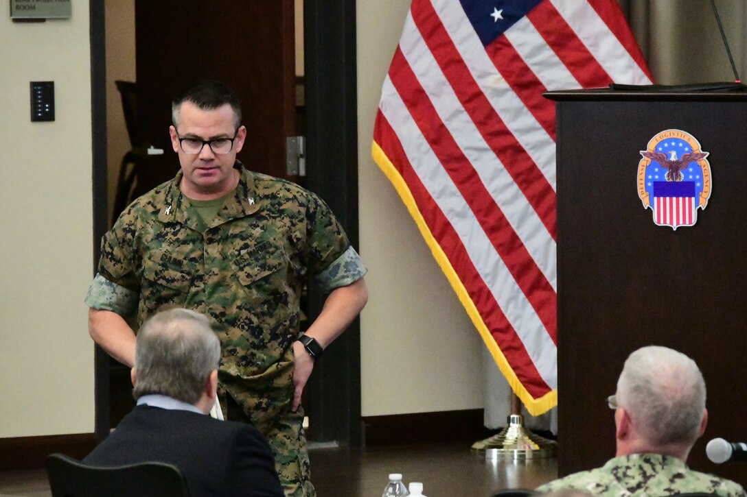 US Marine addresses leaders seated at a table.