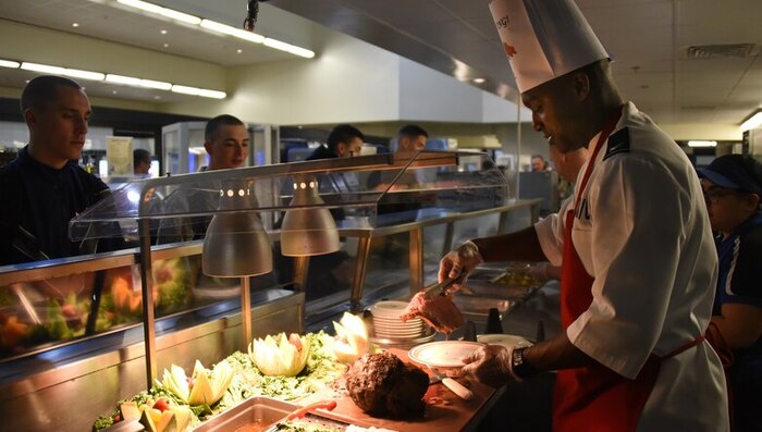 senior leader serves ham at a DFAC