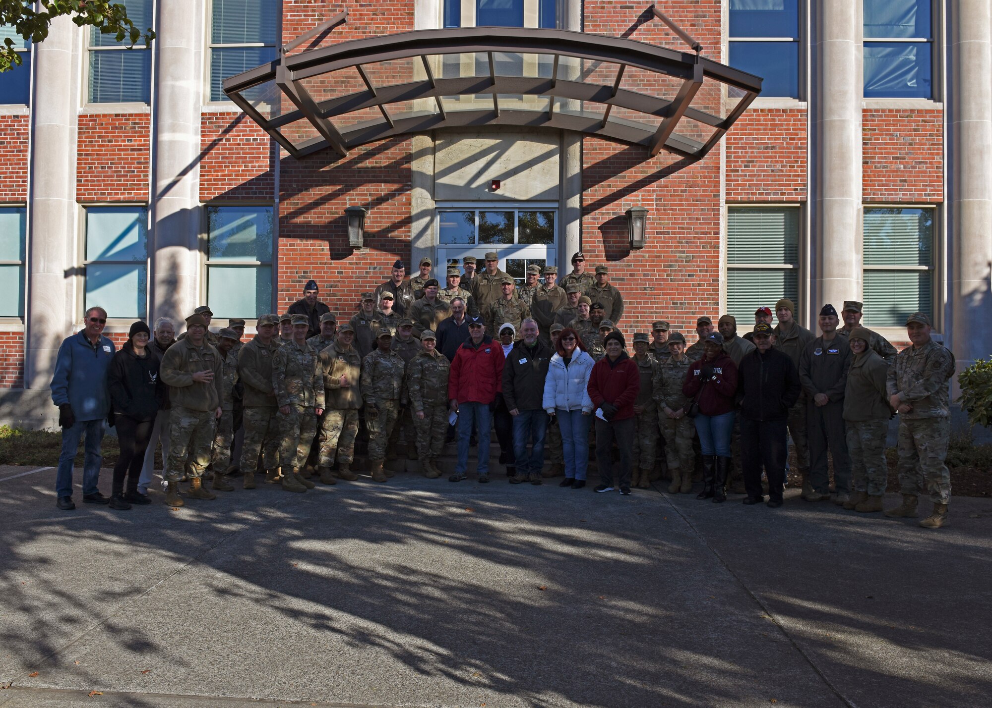 Team McChord Airmen pose for a group photo alongside members of the Air Force Association Washington State Chapter and Pierce Military and Business Alliance after carrying out Operation Turkey Drop at Joint Base Lewis-McChord, Washington, Nov. 18, 2022. Operation Turkey Drop is an event in which the community, local businesses and leadership from around JBLM give out turkeys to Team McChord Airmen and their families in celebration of Thanksgiving. (U.S. Air Force photo by Staff Sgt. Zoe Thacker)