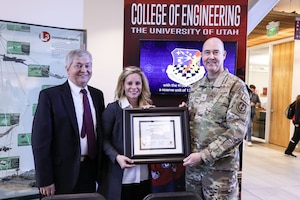 U. of U. College of Engineering Dean Richard Brown, U. of U. Vice President for Research Erin Rothwell, and Ogden Air Logistics Complex Commander Brig. Gen. Richard W. Gibb appear with a framed copy of the partnership agreement.