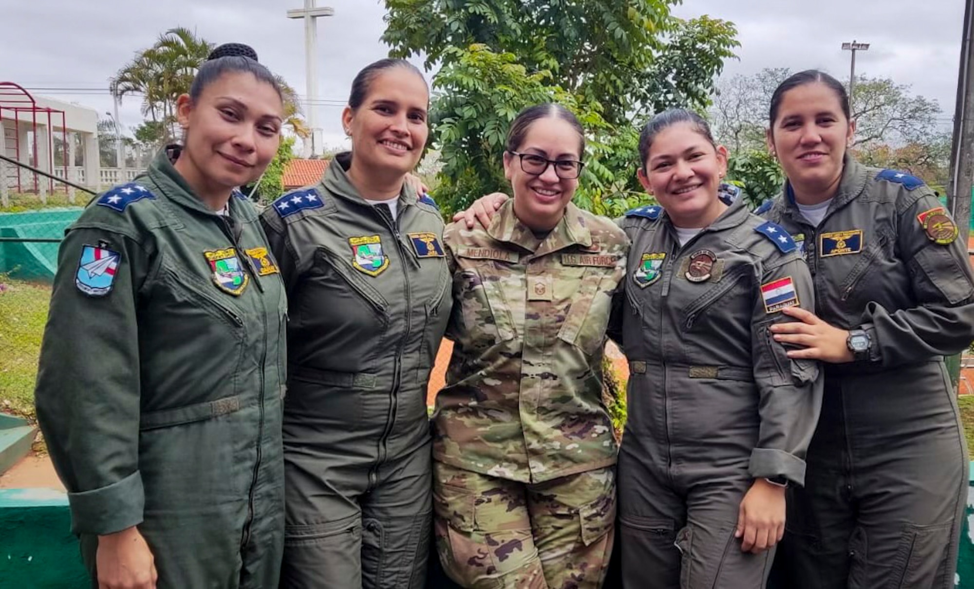 U.S. Air Force Master Sgt. Ana Mendiola, middle, the 571st Mobility Support Advisory Squadron (MSAS) training flight chief, pauses for a photo with four Paraguayan military service members, Sept. 29, 2022 in Paraguay. The 571st MSAS visited Paraguay to train their Air Force and build partnership capacity. During their visit, the first flight between the two Air Force units was operated and completed solely by an all-female aircrew and led by a female Paraguayan pilot. (Courtesy Photo)