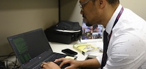 NCIS Special Agent works with a forensic computer in the cyber division.