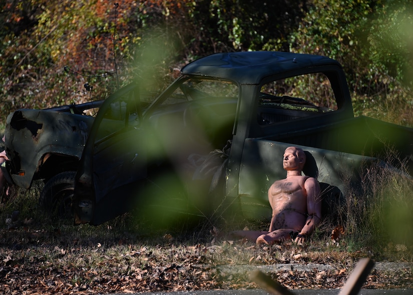 A manikin representing a human victim rests against a truck during Tactical Combat Casualty Care training at Joint Base Andrews, Md., Nov. 18, 2022. The TCCC training consisted of moving towards injured victims, then performing proper emergency care methods and practicing evacuation by helicopter. (U.S. Air Force photo by Airman 1st Class Austin Pate)