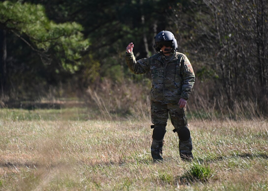 A 1st Helicopter Squadron Airman guides others towards him during Tactical Combat Casualty Care training at Joint Base Andrews, Md., Nov. 18, 2022. The TCCC training consisted of moving towards injured victims, then performing proper emergency care methods and evacuation by helicopter. (U.S. Air Force photo by Airman 1st Class Austin Pate)