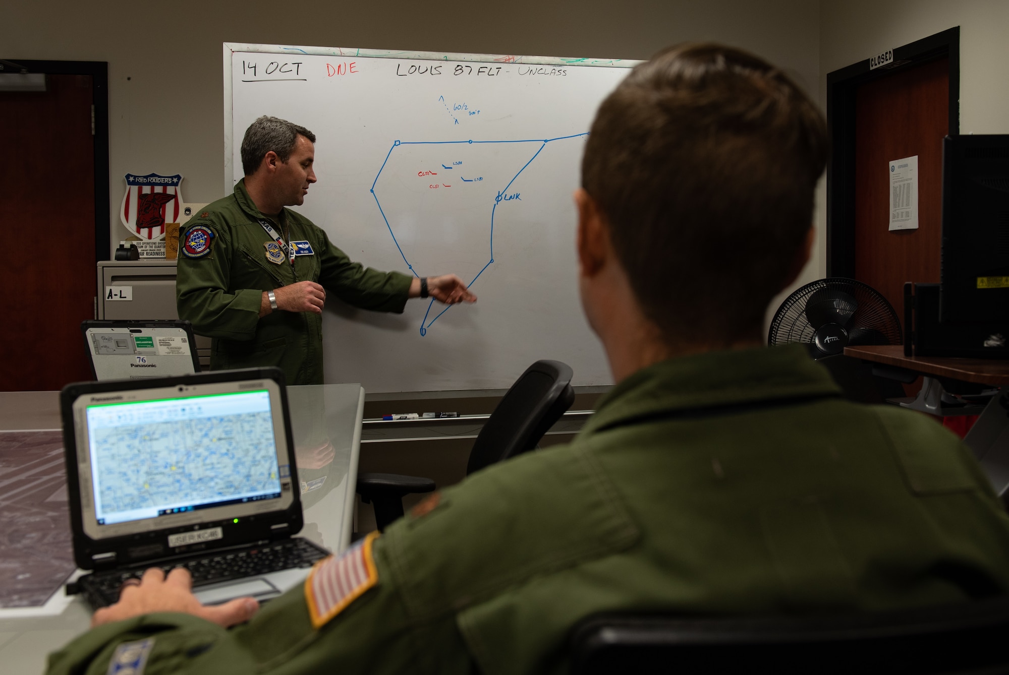 Maj. Jon Avera, 22nd Operations Group Mission Planning Cell (MPC) director, briefs Maj. Donald Clabaugh, 22nd Air Refueling Wing Advanced Programs officer, on an upcoming mission Oct. 13, 2022, at McConnell Air Force Base, Kansas. The MPC is responsible for all the mission planning for the KC-135 Stratotanker, KC-46A Pegasus and their air crews that leave McConnell. (U.S. Air Force photo by SSgt. Tryphena Mayhugh)