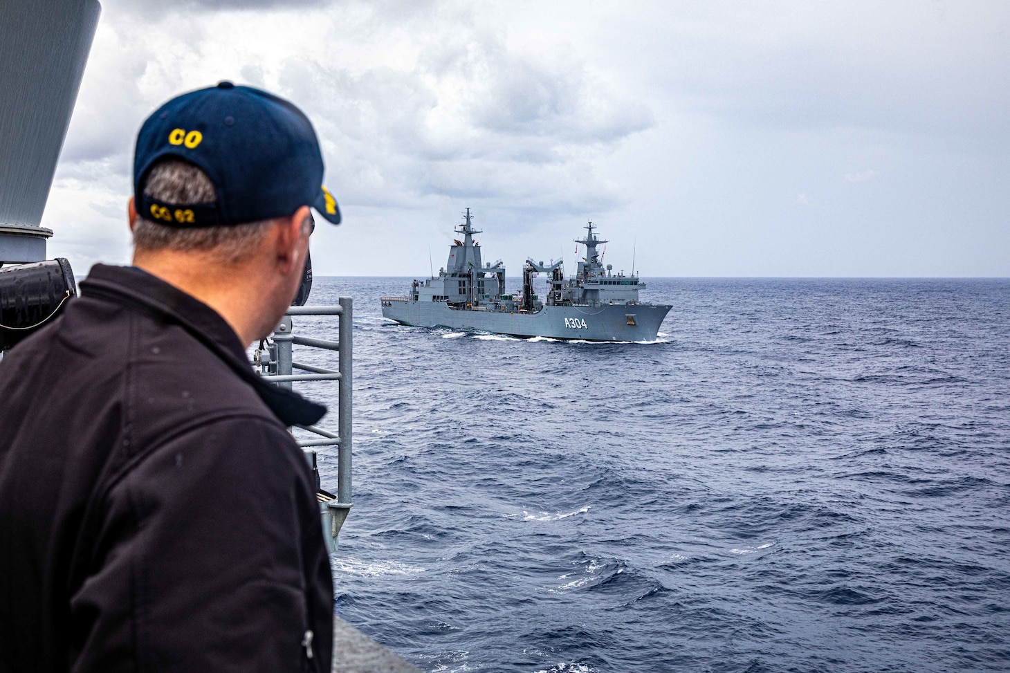 PHILIPPINE SEA (Nov. 20, 2022) Capt. Edward Angelinas views the Royal Australian Navy HMAS Stalwart (A304) on the bridge wing aboard Ticonderoga-class guided-missile cruiser USS Chancellorsville (CG 62) as Carrier Strike Group (CSG) 5 units conduct tri-lateral operations with JS Setogiri (DD 156) of the Japan Maritime Self-Defense Force (JMSDF) and the Royal Australian Navy, to focus on allied interoperability training in the areas of sustainment capability and high end warfighting in the Philippine Sea, Nov. 20. Chancellorsville is forward-deployed to the U.S. 7th Fleet in support of security and stability in the Indo-Pacific and is assigned to Commander, Task Force 70, a combat-ready force that protects and defends the collective maritime interest of its allies and partners in the region. (U.S. Navy photo by Mass Communication Specialist 2nd Class Justin Stack)