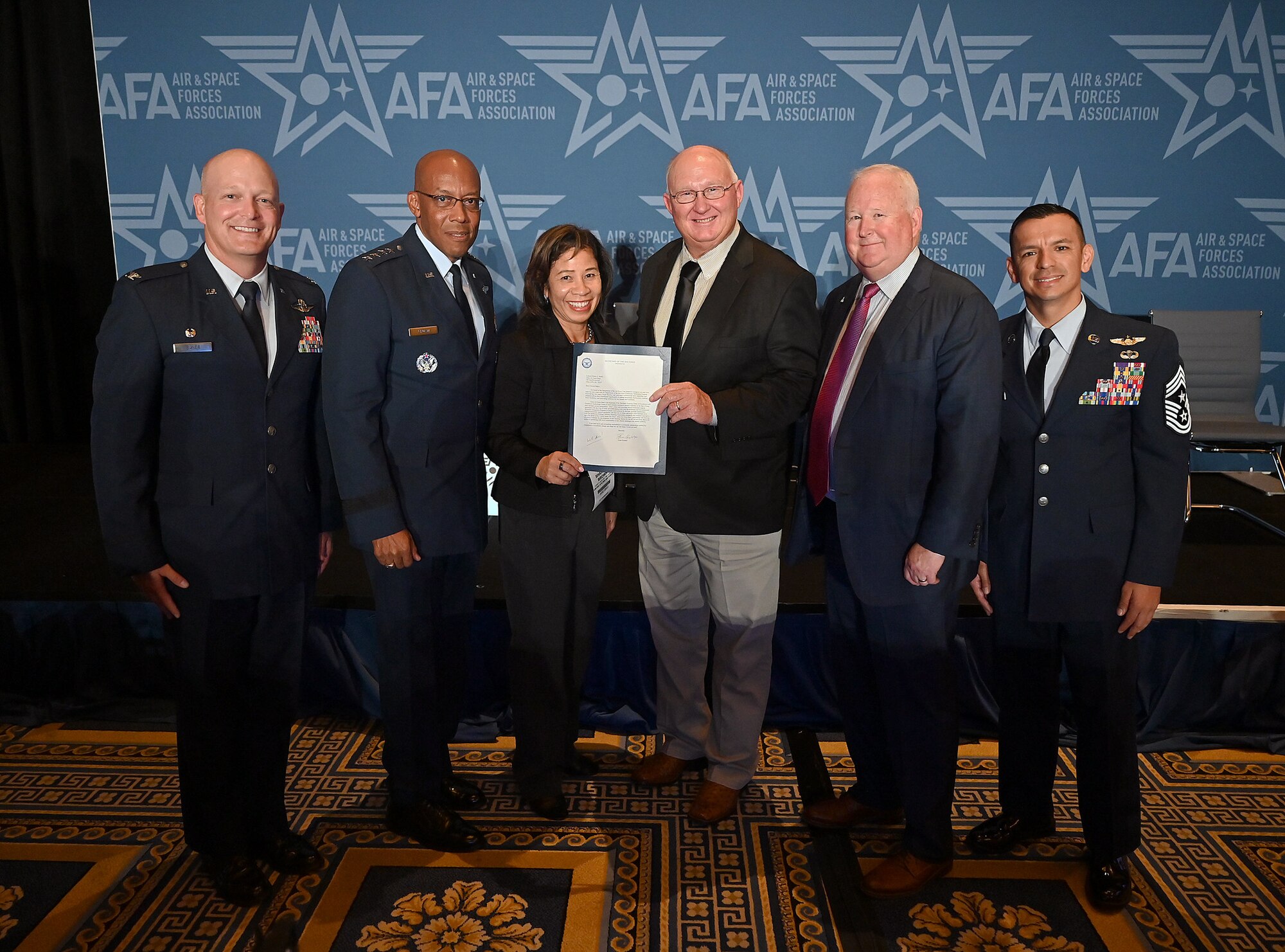 Gen. Charles Q. Brown Jr., (second to the left) Chief of Staff of the Air Force and his wife, Sharene (middle left), present the Community Partnership letter of excellence to Charles Butchee, the Altus Air Force Base Community Partnership Lead, and Dr. Joe Leverett, Chairman of the Altus Military Affairs Committee (second to the right). Col. Blaine Baker (left), 97th Air Mobility Wing (AMW) commander also joined to celebrate the award with Chief MSgt. Cesar Flores, 97th AMW command chief. (U.S. Air Force photo courtesy of Staff Sgt. Chad Trujillo)