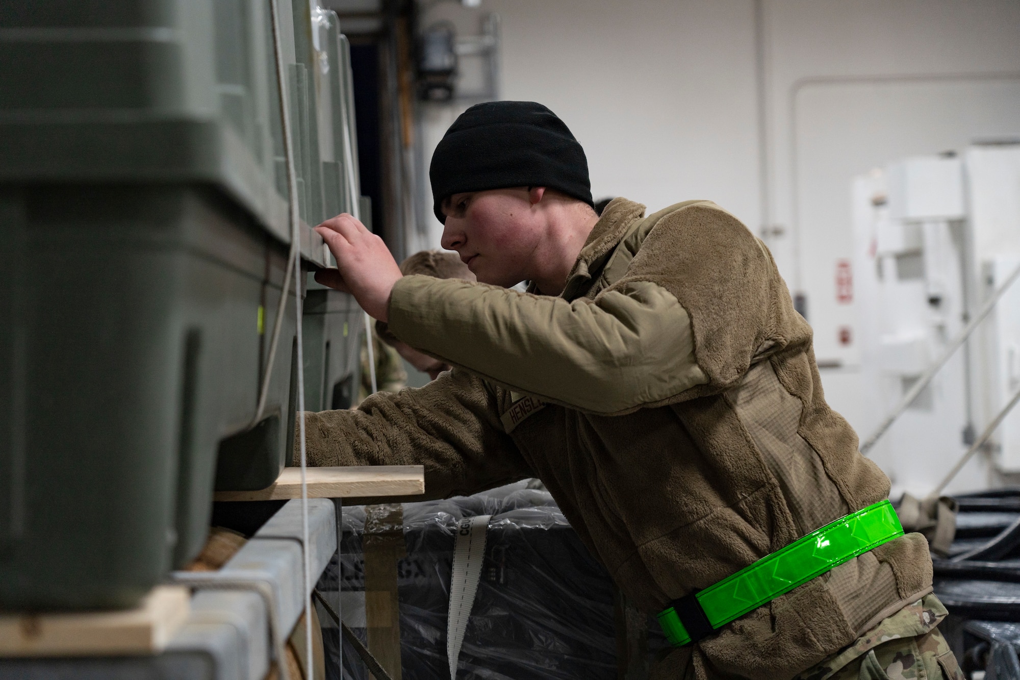 an airman checks to see if a box is secured correctly