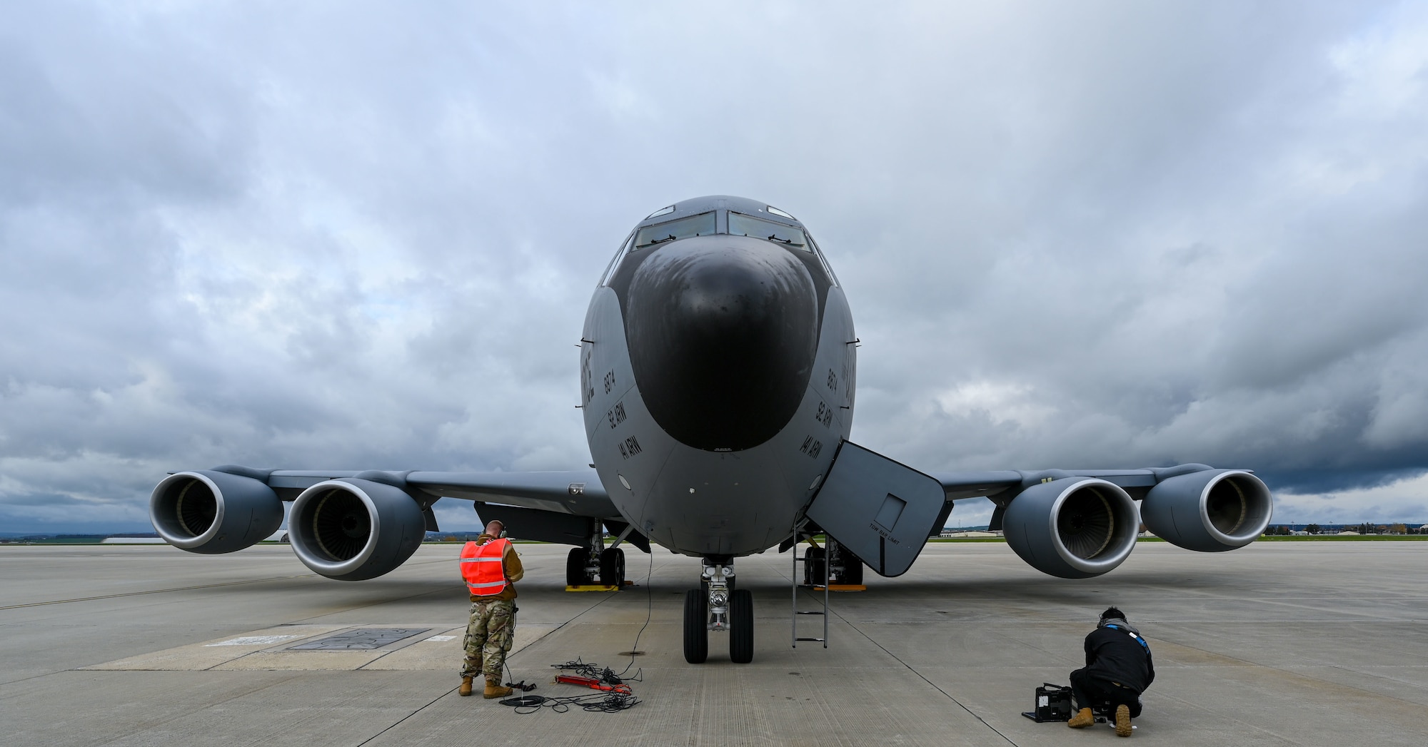 Two Airmen are in front of an aircraft.