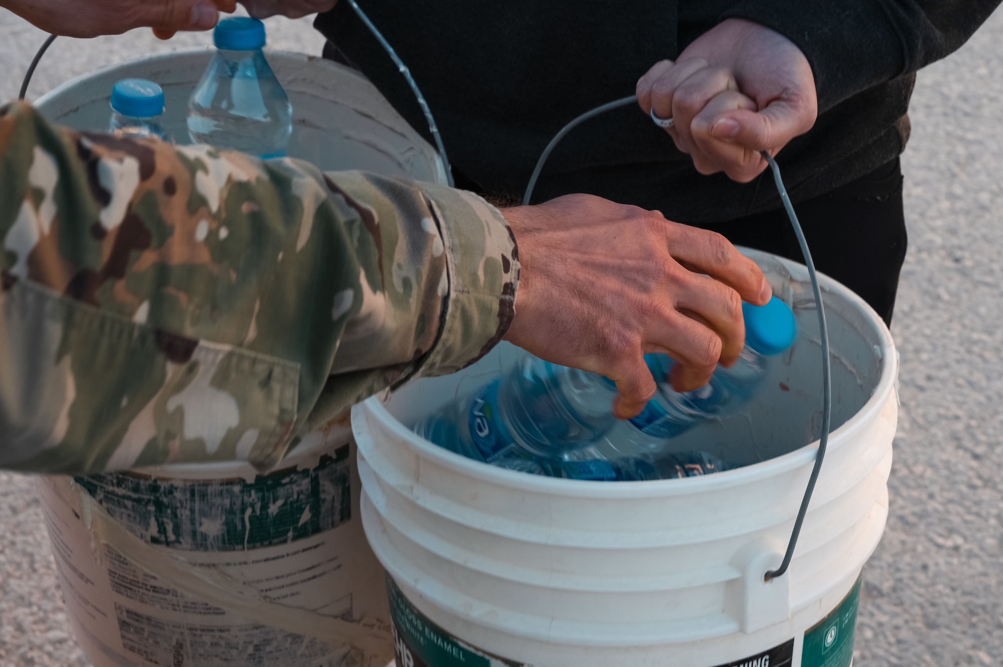 An Airman from the 332d Air Expeditionary Wing fills buckets during the “I Got Your Six” challenge at an undisclosed location, Nov. 19, 2022. The challenge substituted water bottles for stressors that Airman might face in a deployed setting and alerted them to the agencies that are there to assist during trying times. (U.S. Air Force photo by Tech. Sgt. Richard Mekkri)