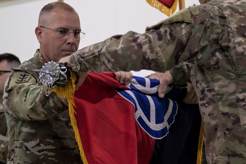 (Left) Maj. Gen. William B. Blaylock II, commanding general of 35th Infantry Division, helps case the colors with Command Sgt. Steven Stuenkel, command sergeant major of the 35th ID, during the Task Force Spartan transfer of authority on Nov. 20, 2022 at Camp Arifjan, Kuwait. The 35th ID cased their colors and transfered the authority of the mission to the 28th Infantry Division (U.S. Army photo Master Sgt. Matthew Keeler).