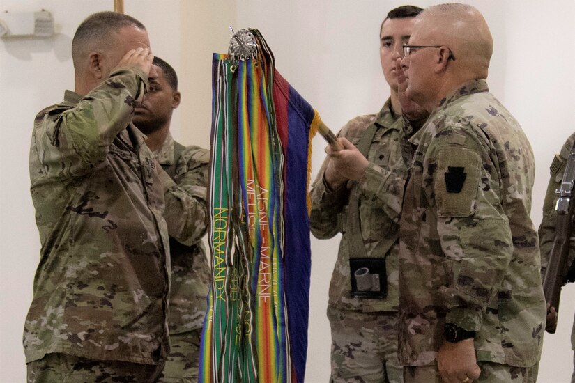 (left to right) Maj. Gen. Mark McCormack and Command Sgt. Maj. Randall Pritts, commanding general and command sergeant major, respectively, of the 28th Infantry Division, salute the colors of the 28th ID during the Task Force Spartan transfer of authority on Nov. 20, 2022. The 28th ID took over the mission from the 35th ID (U.S. Army photo by Master Sgt. Matthew Keeler)