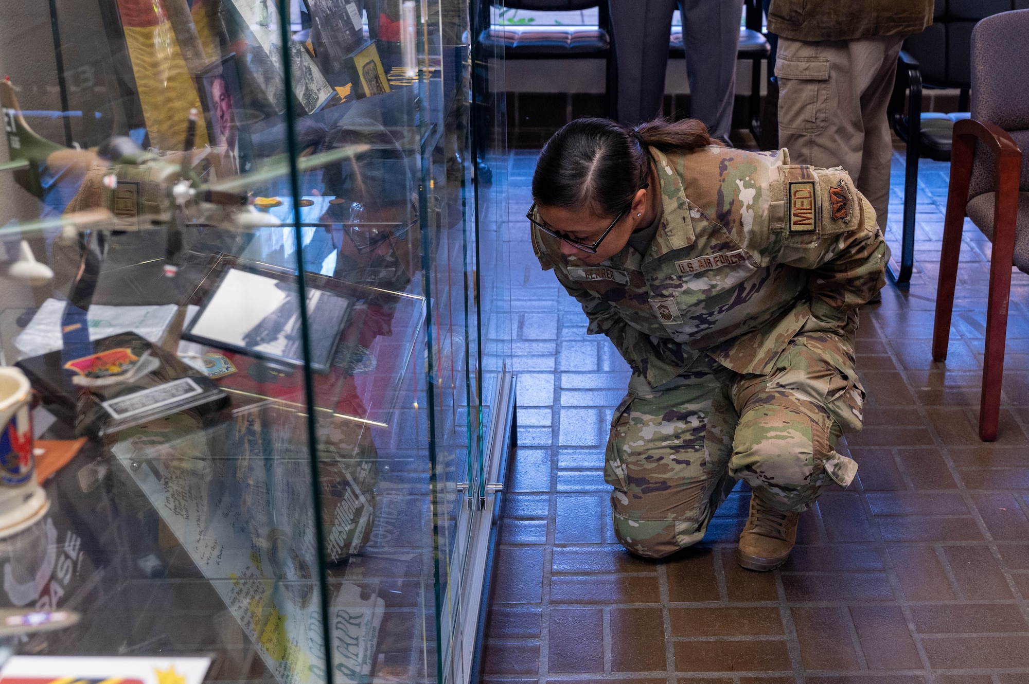 U.S. Air Force Chief Master Sgt. Maribeth Ferrer, 633d Air Base Wing command chief, examines pieces of 633d ABW history from recent history in the Heritage Hall at Joint Base Langley-Eustis, Virginia, Nov. 18, 2022.