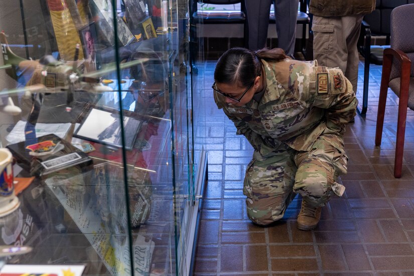 U.S. Air Force Chief Master Sgt. Maribeth Ferrer, 633d Air Base Wing command chief, examines pieces of 633d ABW history from recent history in the Heritage Hall at Joint Base Langley-Eustis, Virginia, Nov. 18, 2022.