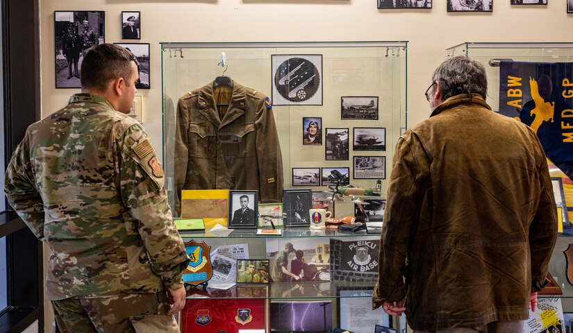 U.S. Air Force Tech. Sgt. Chandler Baker, 633d Air Base Wing Public Affairs noncommissioned officer in charge of mission partner support, and Dr. Christopher McDaid, 733d Mission Support Group archeologist, look at historical artifacts at the grand opening of the 633d ABW Heritage Hall at Joint Base Langley-Eustis, Virginia, Nov. 18, 2022.