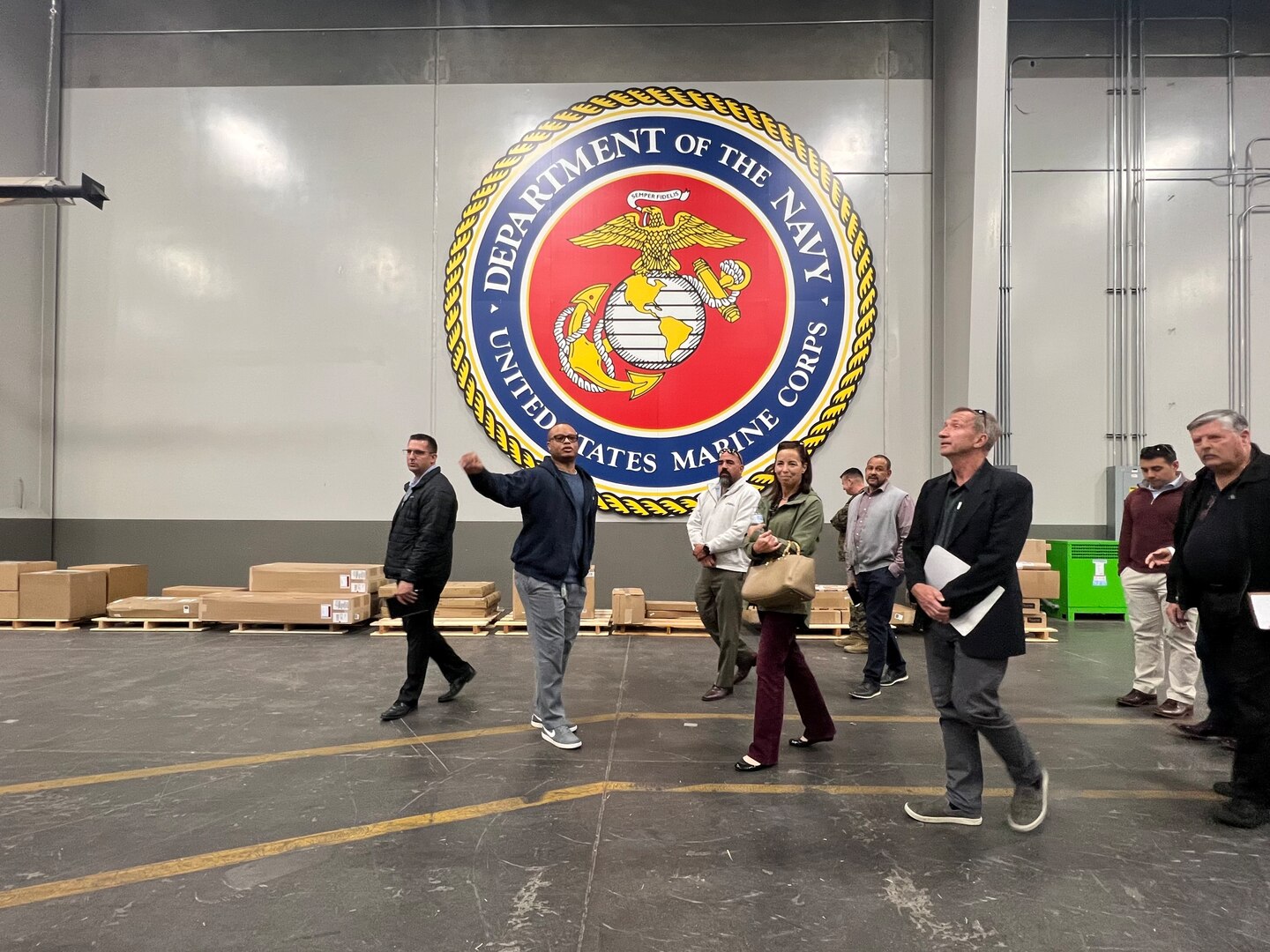 DLA Distribution San Joaquin, California employee Antonie Bethea guides members from the Naval Postgraduate School through a warehouse.