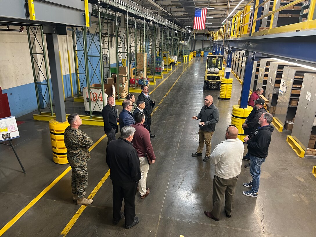 DDJC distribution facilities manager Marc Marquez leads members from the Naval Postgraduate School located in Monterey, California, through a DDJC warehouse.
