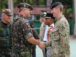 New York Air National Guard Tech Sgt. Jeremy Miter, right, a member of the 274th Air Support Operations Squadron, is congratulated by the chief of Brazil’s world-famous Jungle Warfare Training School in Manas, Brazil, Nov. 17, 2022, after completing the international course. Miter attended the course as part of the State Partnership Program agreement between Brazil and the New York National Guard.
