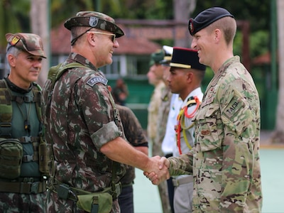 New York Air National Guard Tech Sgt. Jeremy Miter, right, a member of the 274th Air Support Operations Squadron, is congratulated by the chief of Brazil’s world-famous Jungle Warfare Training School in Manas, Brazil, Nov. 17, 2022, after completing the international course. Miter attended the course as part of the State Partnership Program agreement between Brazil and the New York National Guard.