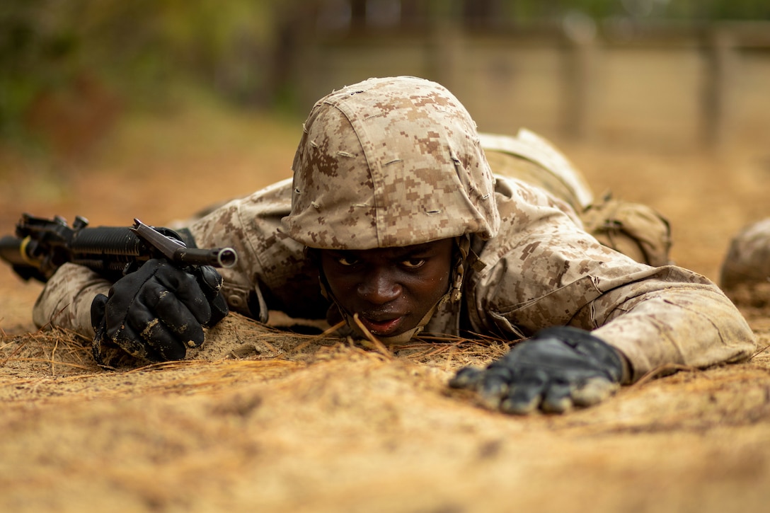 A Marine crawls along the ground.