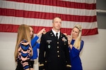 Dustin McNeely, an Army aviator with Company C, 2nd Battalion, 245th Aviation Regiment, 90th Troop Command, is pinned as a Chief Warrant Officer 5 during his promotion ceremony held in Oklahoma City, Nov. 17, 2022. McNeely's wife Chasity and daughters Vivian and Elise pinned his new rank during the ceremony. (Oklahoma National Guard photo by Sgt. 1st Class Mireille Merilice-Roberts)