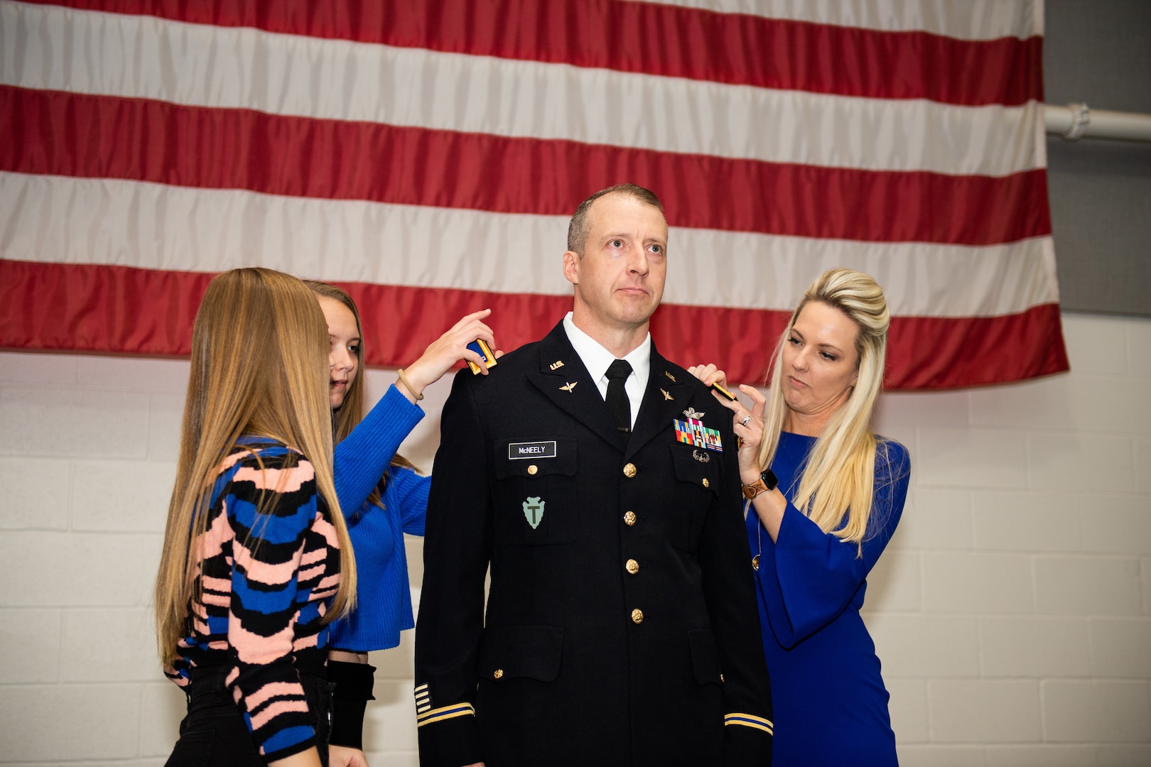 Dustin McNeely, an Army aviator with Company C, 2nd Battalion, 245th Aviation Regiment, 90th Troop Command, is pinned as a Chief Warrant Officer 5 during his promotion ceremony held in Oklahoma City, Nov. 17, 2022. McNeely's wife Chasity and daughters Vivian and Elise pinned his new rank during the ceremony. (Oklahoma National Guard photo by Sgt. 1st Class Mireille Merilice-Roberts)