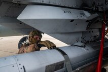 Navy SEAL adjusts weapon