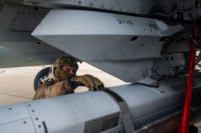 Navy SEAL adjusts weapon