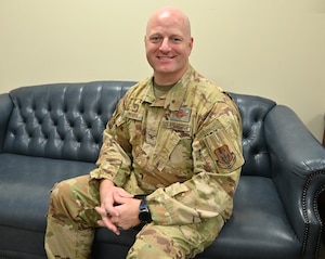 Commander sits on couch in his office