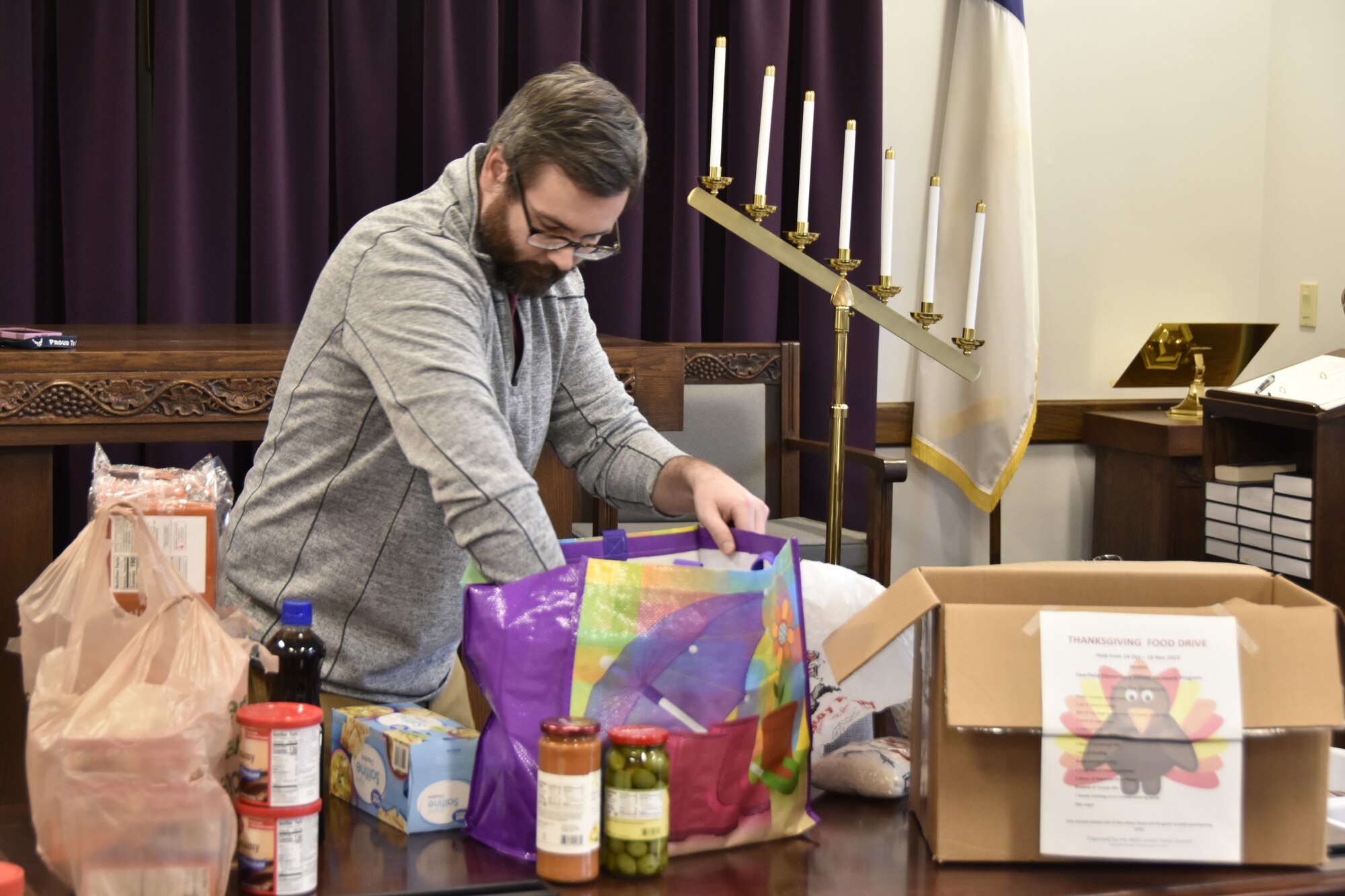 AEDC team member Adam Moon checks one of the bags of food donated as part of a food drive.