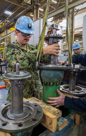 Dylan Whaley, an electrician's mate third class assigned to USS Theodore Roosevelt (CVN 71), assists with a valve repair in Shop 31, Machinists, Electroplaters & Toolmakers. Sailors were trained on repairs in a new collaboration between the shop and the ship. (U.S Navy Photo by Wendy Hallmark)