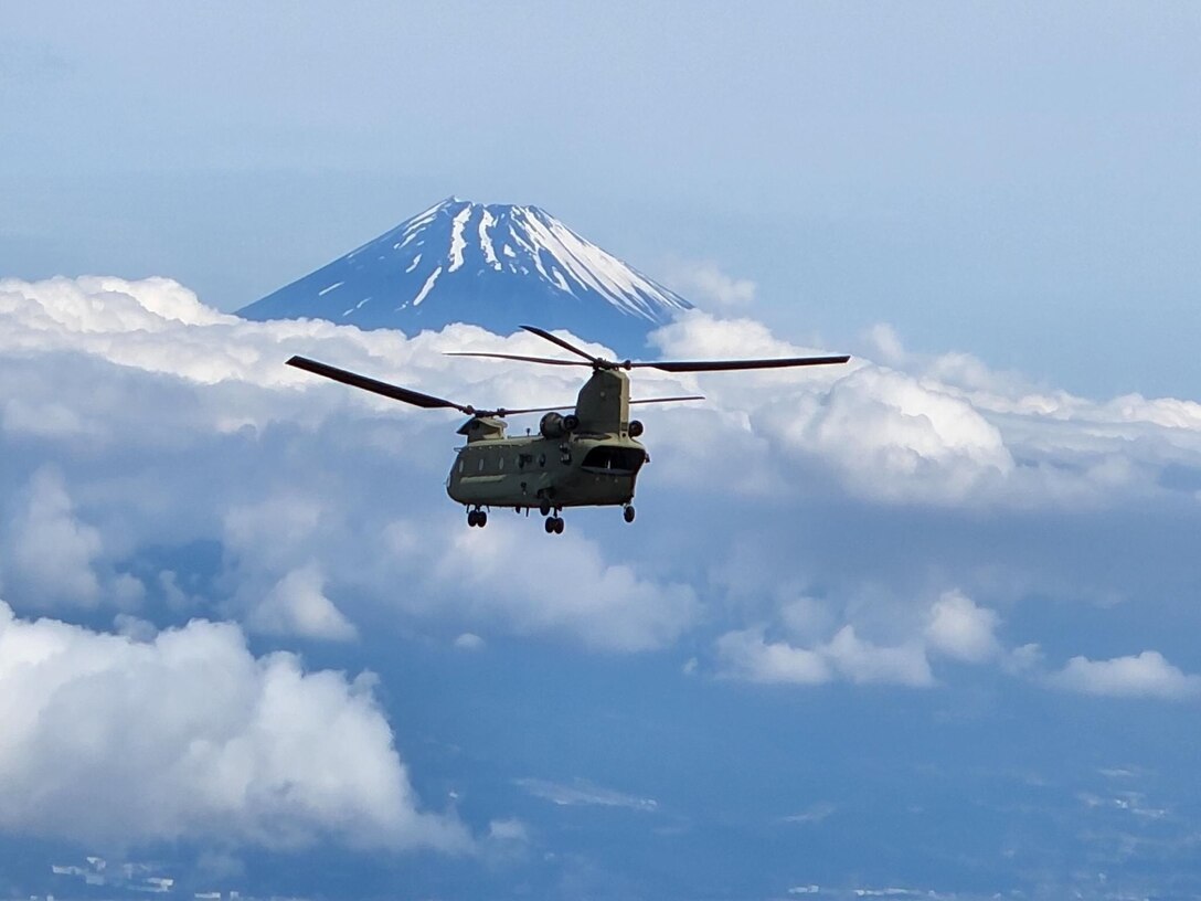 A CH-47 Chinook helicopter flies near Mount Fuji in Japan on its return home journey during 3-2 General Support Aviation Battalion's support to President Biden during his time in Japan. Courtesy photo provided by Sgt. First Class David Linscott.