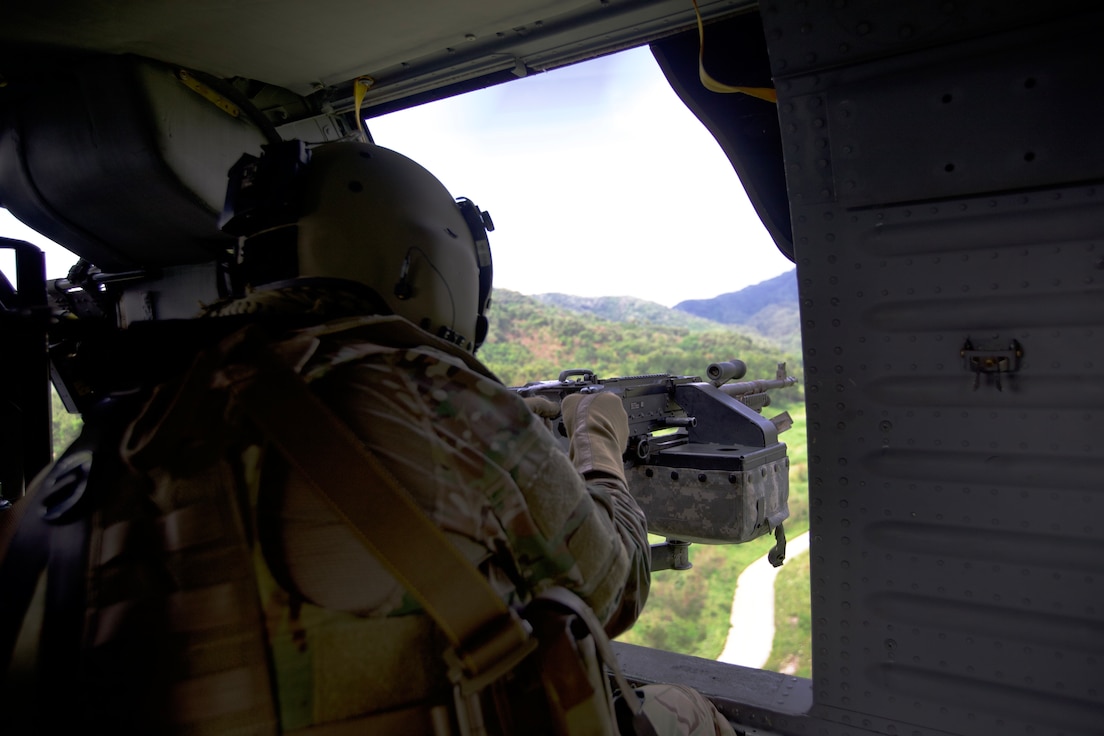 U.S. Army Soldiers from 2nd Battalion, 2nd Aviation Regiment, 2nd Combat Aviation Brigade, 2nd Infantry Division/ROK-U.S. Combined Division participate in dual door gunnery in their semi-annual door gunnery training exercise from June 21 to 25, 2022. A crew member fires the M240H light machine gun out of the door of a UH-60M Black Hawk helicopter.