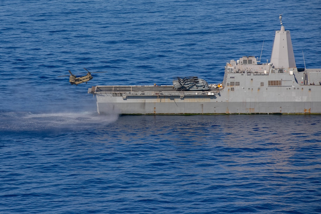A U.S. Army Boeing CH-47F prepares to land on the USS Portland (LPD 27) in the Pacific Ocean off the coast of Oahu, Hawaii, Feb. 18, 2022. The joint service training was a part of a deck landing qualification held to maintain proficiency in supporting maritime missions in the Indo-Pacific region. (U.S. Army photo by SGT Carlie Lopez/28th Public Affairs Detachment.)