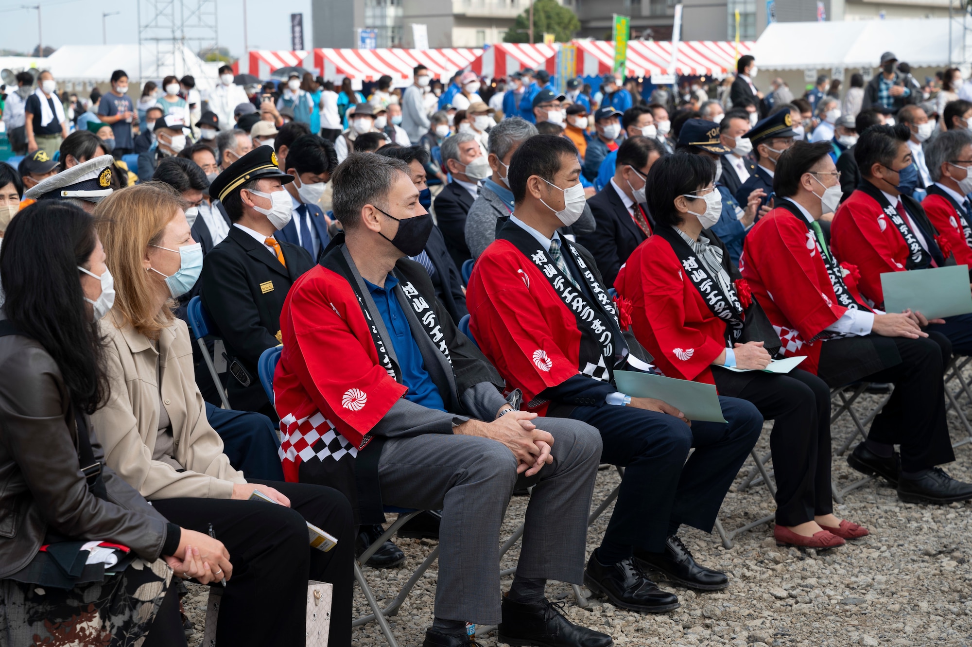 Festival attendees sitting in chairs listening to opening remarks