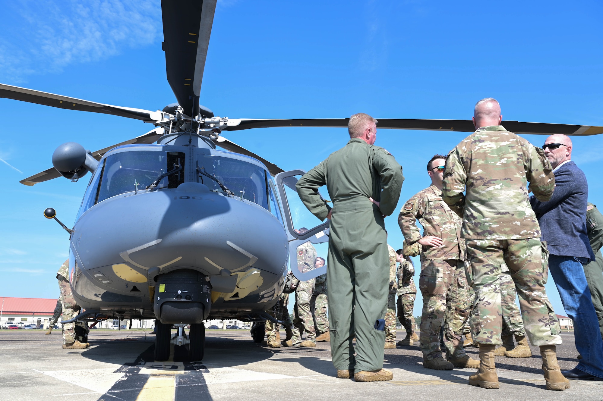 members congregate next to helicopter