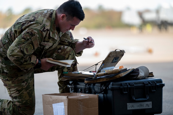 Pictured above is a man in a military uniform working over a pelican case.